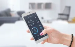 Une femme utilise un téléphone intelligent pour contrôler sa consommation énergétique, représentant le travail de CGI avec GRDF