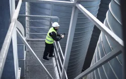 Factory worker standing on metal platform
