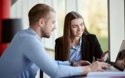 CGI Sustainability consultants look at laptop together