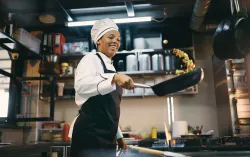 Chef sautéing over a grill