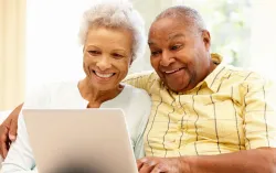 elderly couple using laptop