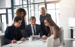 Consultants meeting around table with tablet