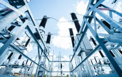 Poste électrique à haute tension avec charpente métallique et isolateurs sous un ciel bleu