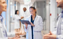 Médecin utilisant une tablette dans le couloir de l’hôpital