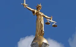 Golden statuette of Lady Justice atop building