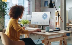 femme assise à un bureau, étudiant un écran avec des données