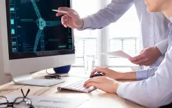 two people analyzing wind turbine data on a monitor