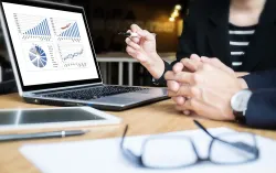 un dirigeant de banque examine les graphiques de données sur le moniteur