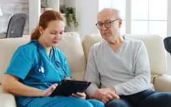 Elderly patient videoconferencing with doctor from their home using a laptop