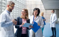 Fachpersonen im Austausch im klinischen Umfeld als Symbol für sichere, zentral gesteuerte digitale Gesundheitsinfrastruktur und TI-Anbindung.