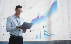 IT programmer working on computer in data center system control room