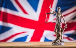 Lady Justice statue in front of Union Jack flag