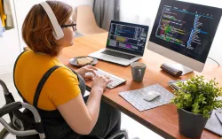 Person working at a desk looking at coding on two computer screens