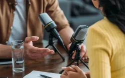 two people sat conversing over a microphone
