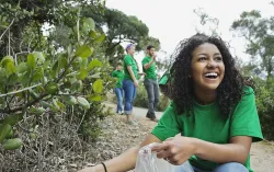 woman smiling picking up litter