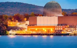 Réacteur nucléaire près d’une rivière, en soirée avec des lumières qui brillent