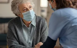 nurse helping elderly patient at home