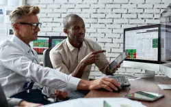 Two adults reviewing financial reports in an office