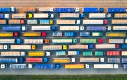 Luftaufnahme zahlreicher Lastwagen auf mehreren Fahrspuren, die parallel und dicht getaktet unterwegs sind