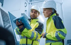 Two utilities workers looking at a digital tablet