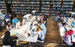 Students sitting arounf a table in a library