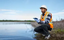 Worker using tablet at water's edge
