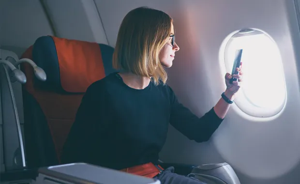 Reisende bruker mobiltelefon til betaling om bord på fly