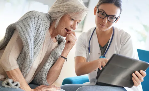 healthcare worker and patient looking at tablet