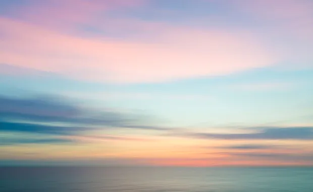 Abstract blurred sky at sunset with blue ocean background