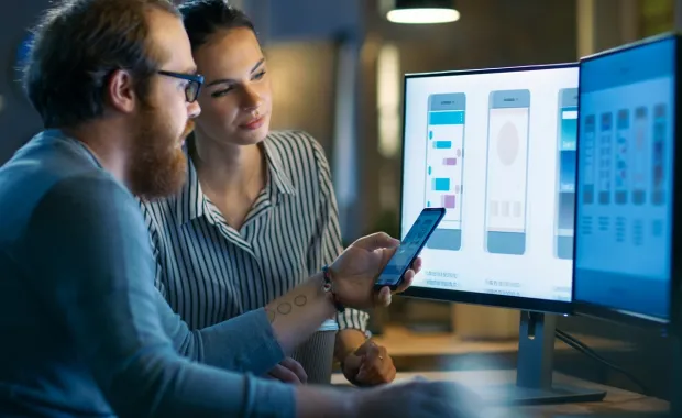 Mobile app designers working on a computer