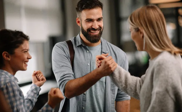 A man and a woman clasping hands in a friendly handshake