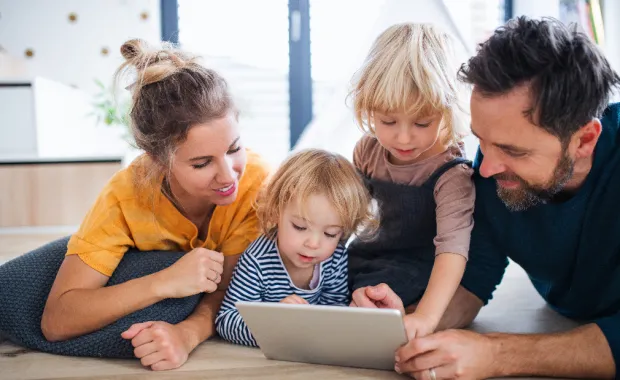 Kuvituskuvassa perhe käyttää yhdessä tabletilta CGI Vesaa