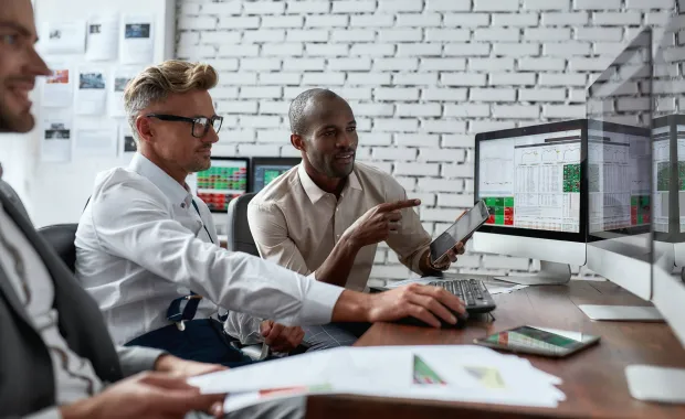3 personnes travaillent devant un ordinateur