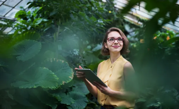 Woman standing in botanical garden with an Ipad