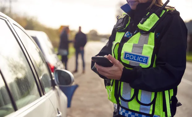 Female traffic police officer recording details of road traffic accident Female traffic police officer recording details of road traffic accident