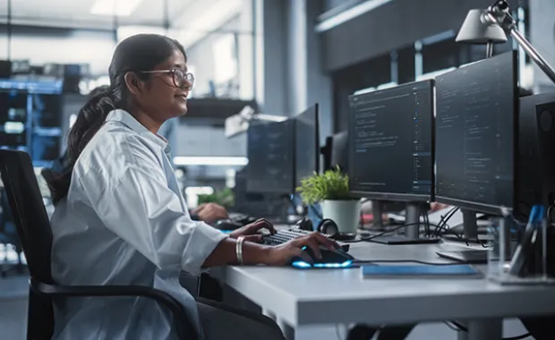 Young Female Artificial Intelligence Engineer Working on Computer in a Technological Office.