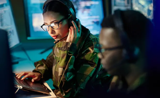 Military professional in a command center listening into a headset