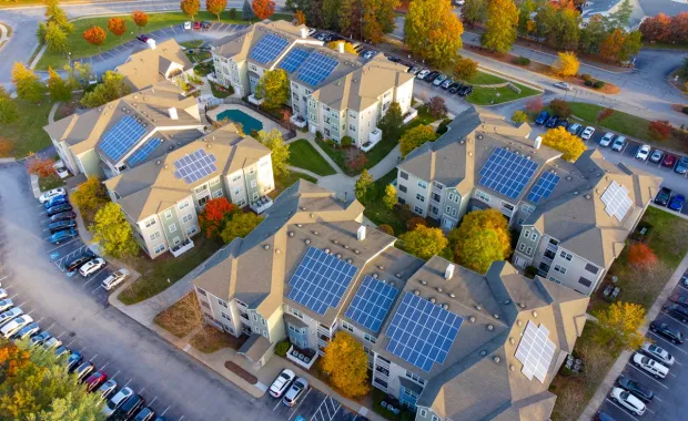 Aerial view of apartment buildings with solar panels on the roofs