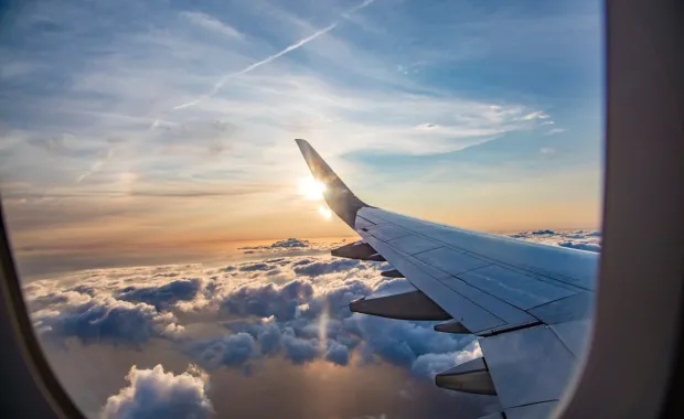 Kuvituskuva: näkymä lentokoneesta pilvien yläpuolella. Agentforce World Tour Helsinki.