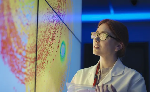 data scientist in a lab coat looking at a screen with big data