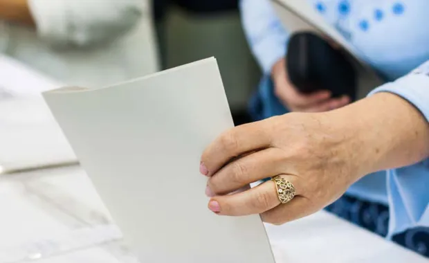 Voter puts paper vote in ballot box