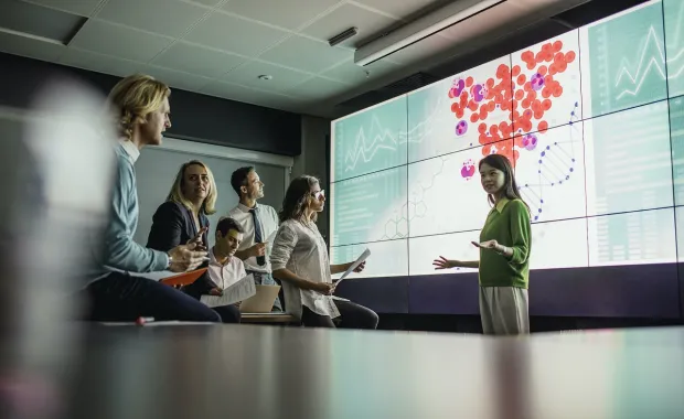 group of life sciences professionals looking at a large screen