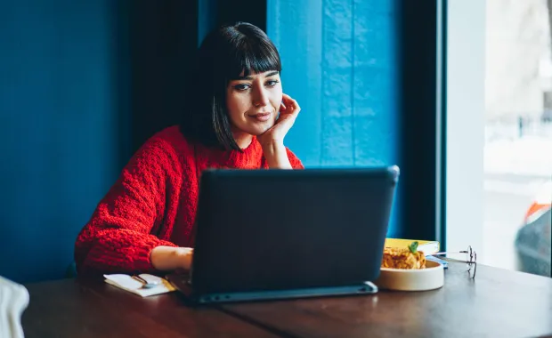 woman sitting at desk on computer in cafe