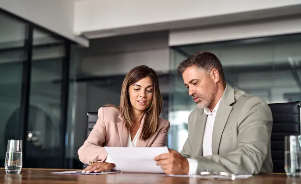Financial advisor reviewing documents with a client in a modern office