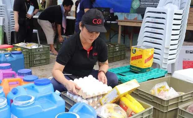 Un bénévole de CGI supervise la distribution de nourriture
