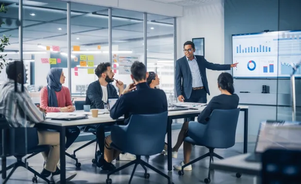 A man leads a presentation to a group of people