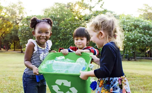 Children holding recycling container