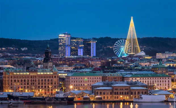 Vybild över ett Göteborg som är upplyst av stadsljus vid vattnet