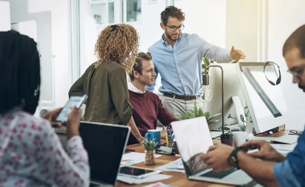 Kuvituskuvassa asiantuntijat keskustelemassa sovellusten modernisoinnista Application Factoryn avulla