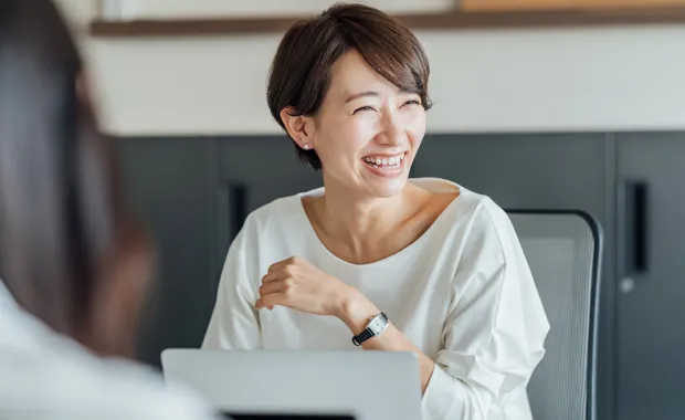 Kvinna ler mot en kollega utanför bild